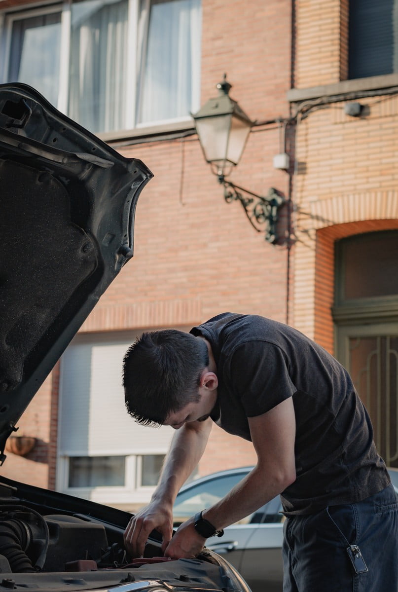 Mecánico desenroscando la bombilla del faro de un coche